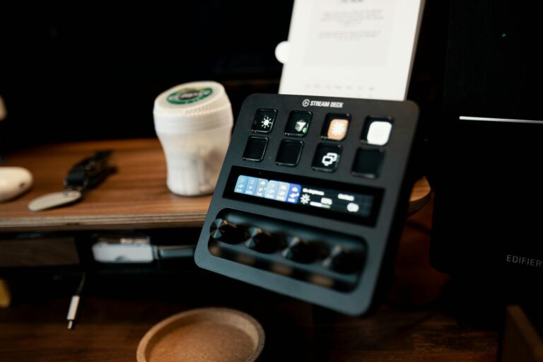 A Stream Deck on a wooden desk, featuring various buttons and controls in a home studio setup.